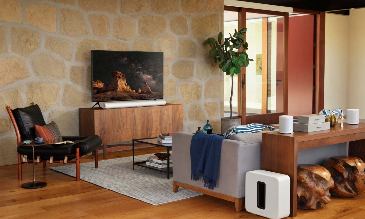 Sonos speakers sitting on console table and sonos sub on floor