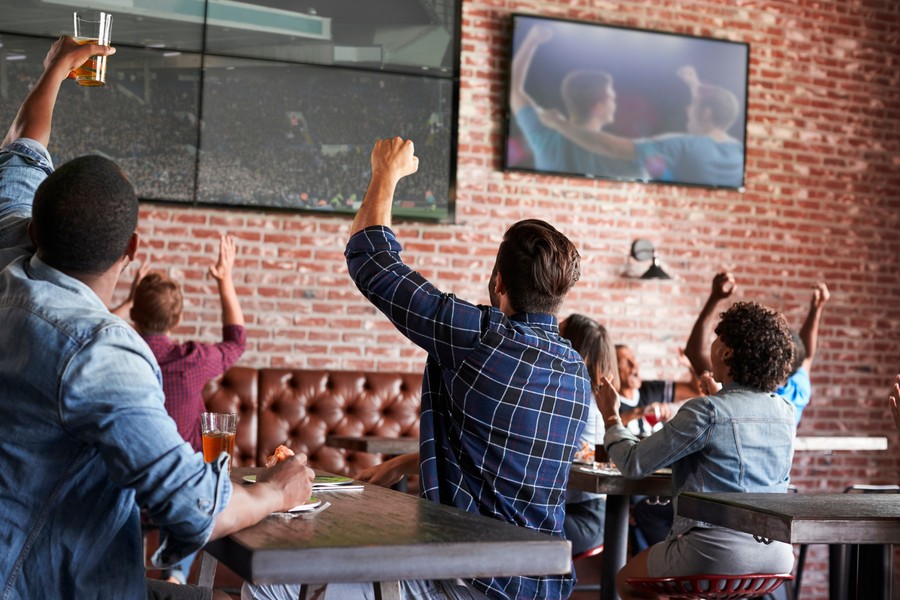 A group of friends celebrating a sporting event at their local sports bar.