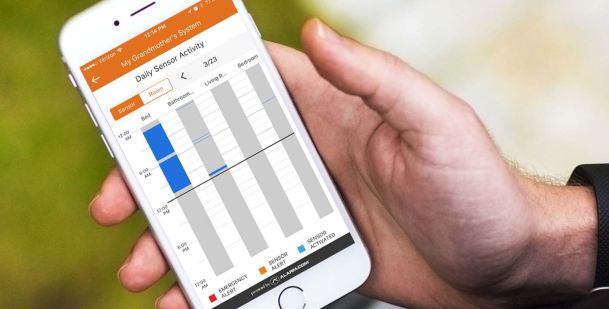 Person holding iphone with alarm.com interface