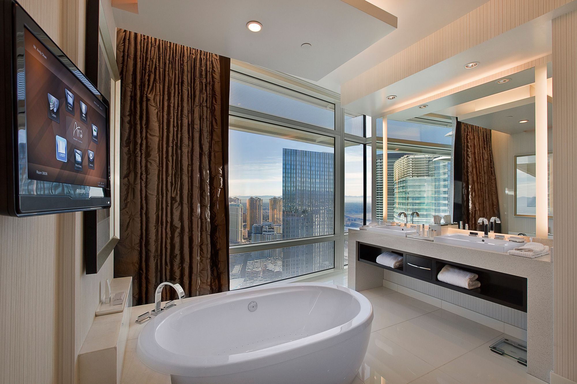 Bathroom with motorized window treatments and lighted mirrors