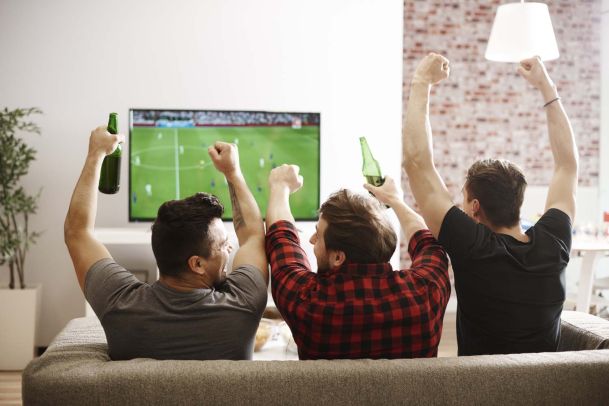 Friends cheering at sports on tv