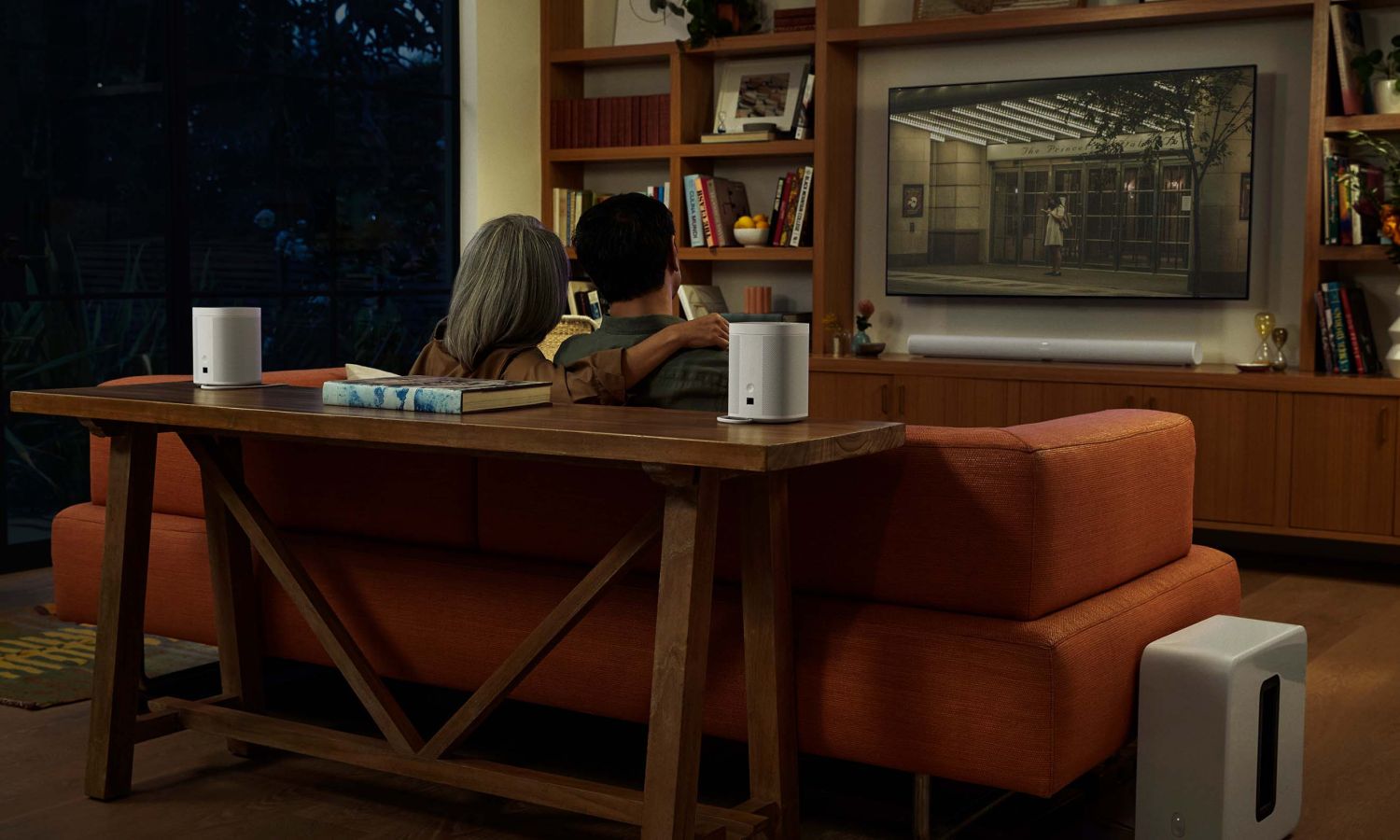 Sonos speakers sitting on console table and sonos sub on floor